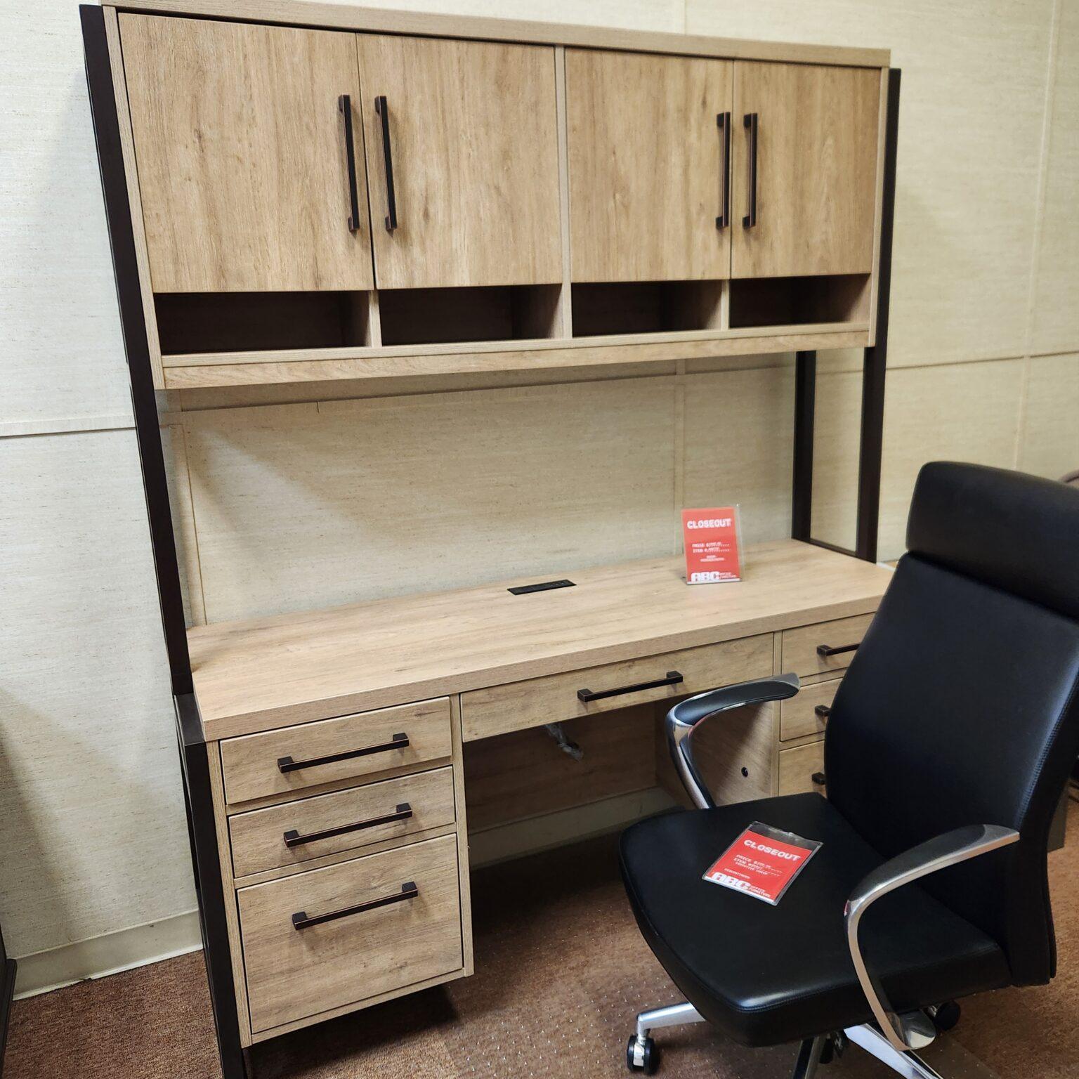 Photo shows the maple-colored desk and hutch set and an office chair.