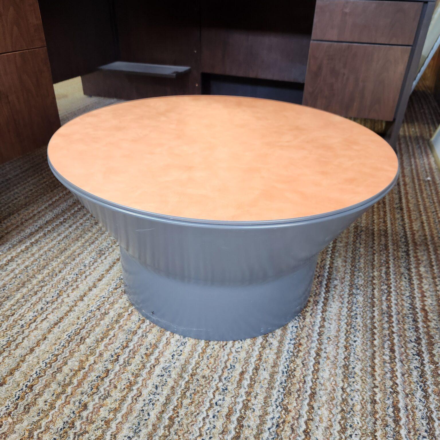 round end table with metal barrel base and orange laminate top